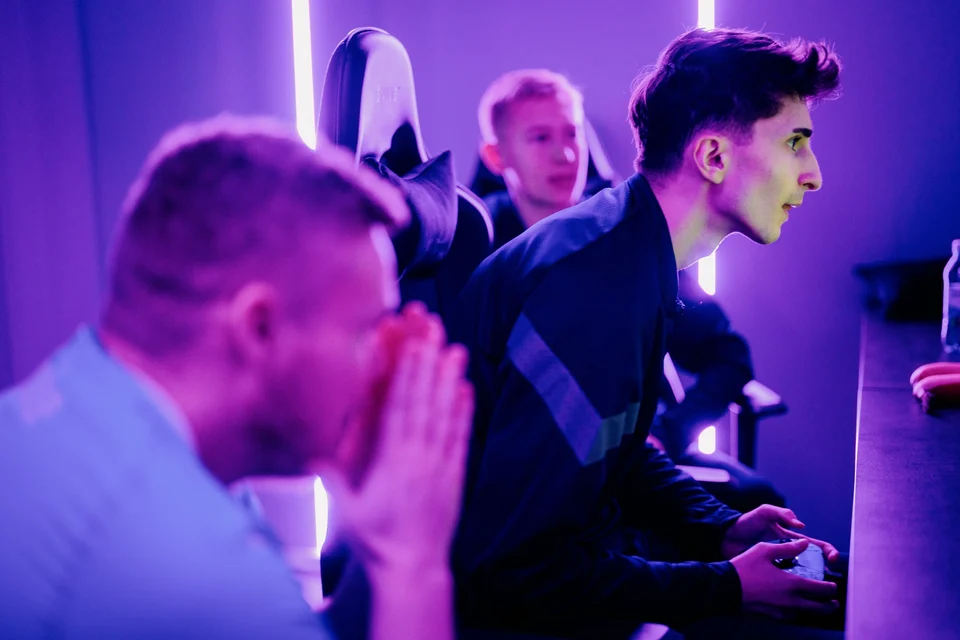 Players using controllers in a purple-lit FUZED gaming space