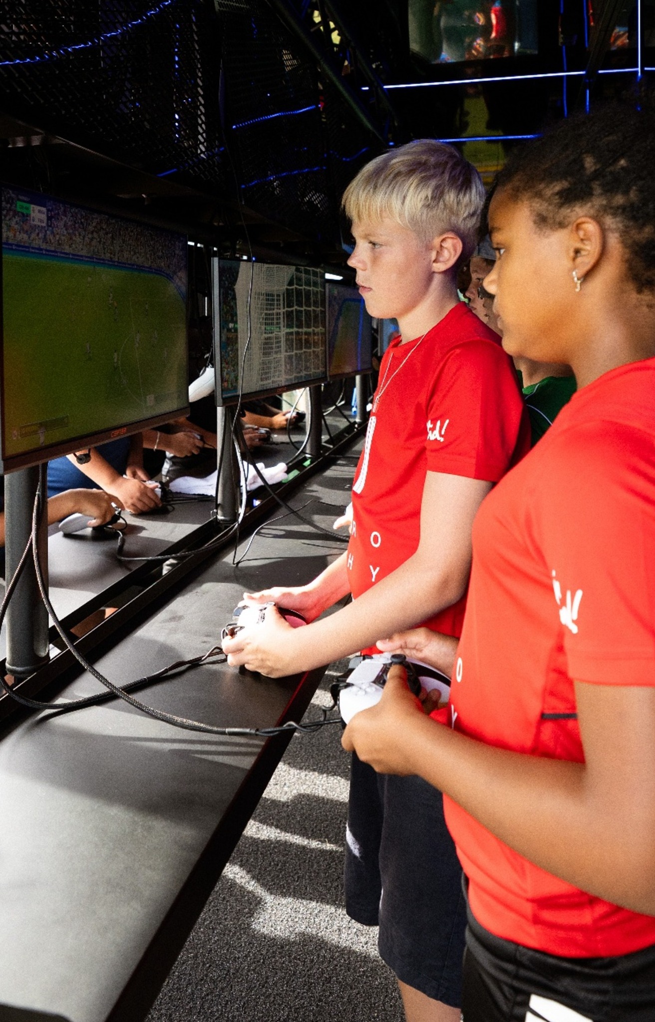 Young players using controllers to compete in a football video game