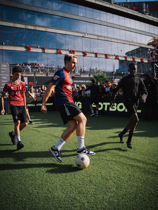 Young footballers competing for the ball on the FUZED pitch